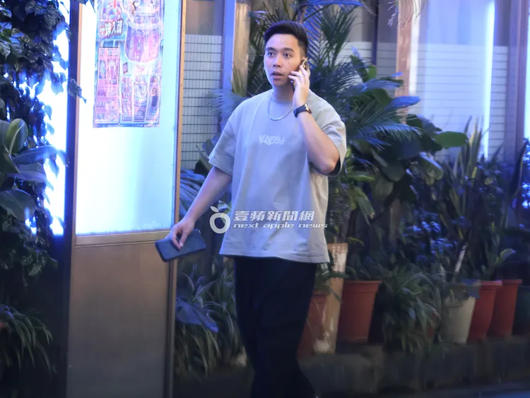 無尊從停車場上來，繼續拿著LV長皮夾講手機。特勤中心攝