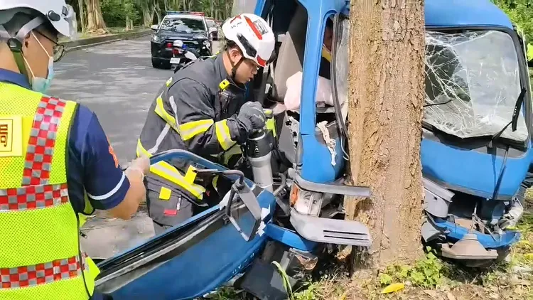 消防人員以切割器破壞變形的車體。民眾提供