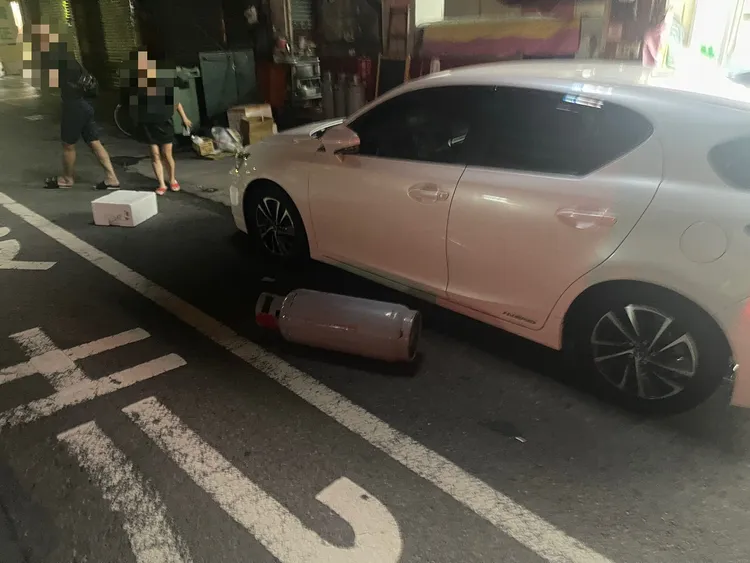 陳男拿路旁的瓦斯桶砸向一部自小客車。翻攝畫面