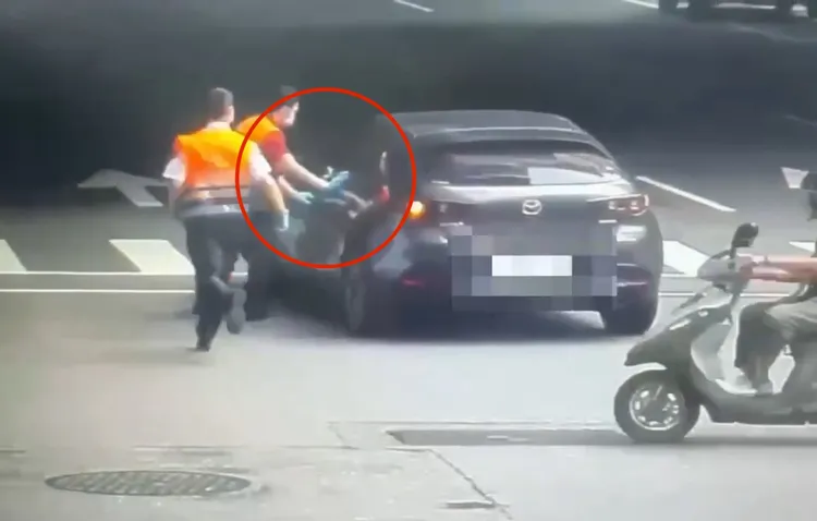 吳男酒駕睡車上被叫醒，突然放開煞車踏板，車輛一度往前滑行撞到分隔島才停下，警消在一旁追趕，試圖開門救人。翻攝畫面
