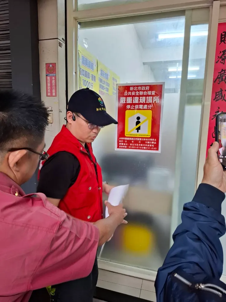 公安小組成員於棋牌社門口張貼嚴重違規場所紅色告示，提醒民眾避免進入。警方提供