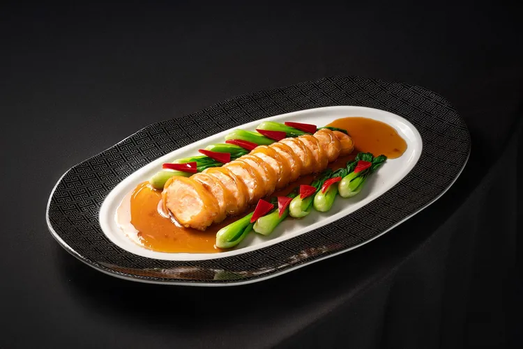 台北凱撒王朝中餐廳以「黃花魚膠釀蝦滑」榮獲「2025亞太十大名菜美點」的殊榮。主廚練禹志嚴選黃花魚膠，蒸製後依古法溫養多日，質地晶瑩柔潤；再以紅燒汁煨煮入味，釀入手工蝦滑蒸熟，膠中藏鮮、口感細緻。台北凱撒大飯店提供