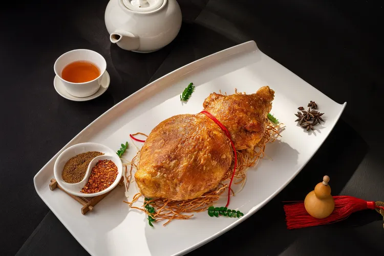 板橋凱撒家宴中餐廳以「長安葫蘆雞」榮獲「2025亞太十大名菜美點」。此菜源自唐朝宮廷御膳，外型似葫蘆，寓意福祿吉祥。選用上等土雞，經煮、蒸、炸三道工序製成，外酥內嫩，風味層次分明，由主廚馮永田傳承古法演繹。板橋凱撒大飯店提供