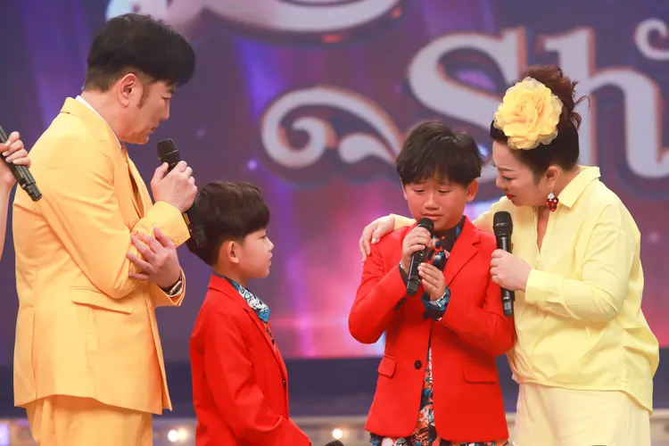 10歲的周柏霖與弟弟周祐均合唱〈落雨聲〉。民視提供