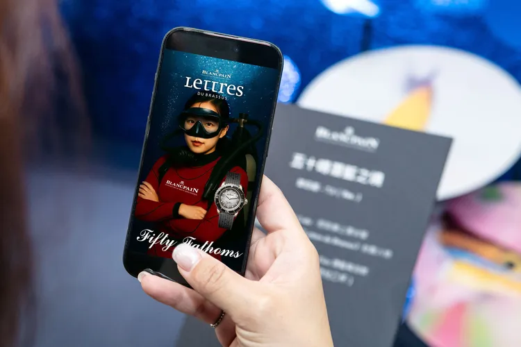 結合海洋意象與AI科技，現場掃描QR Code並上傳照片，即可生成打造專屬個人化的《Lettres du Brassus》封面，以Blancpain贊助之「腔棘魚探險研究隊」紅色潛水服為靈感，化身深海探險家。品牌提供