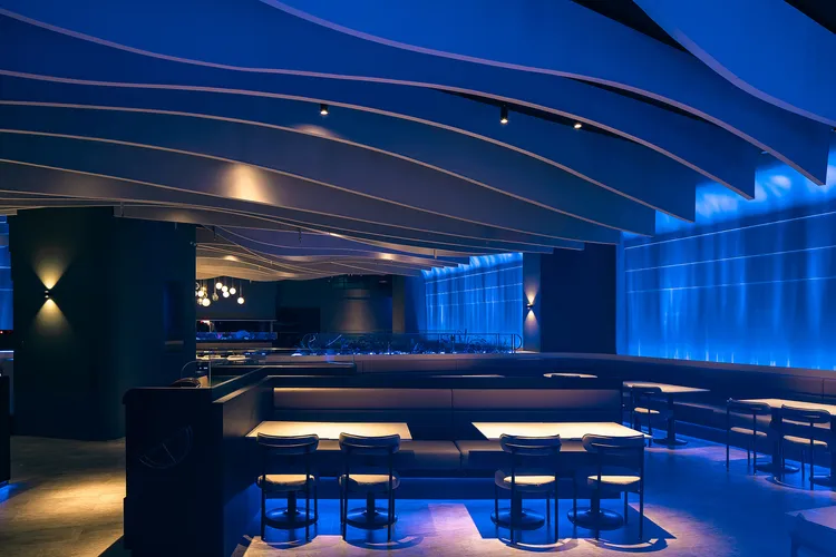 高雄夢時代店牆面與地板間，靜藍柔和的流動光線，如海水折射的自然節奏映照出閃耀變化。業者提供