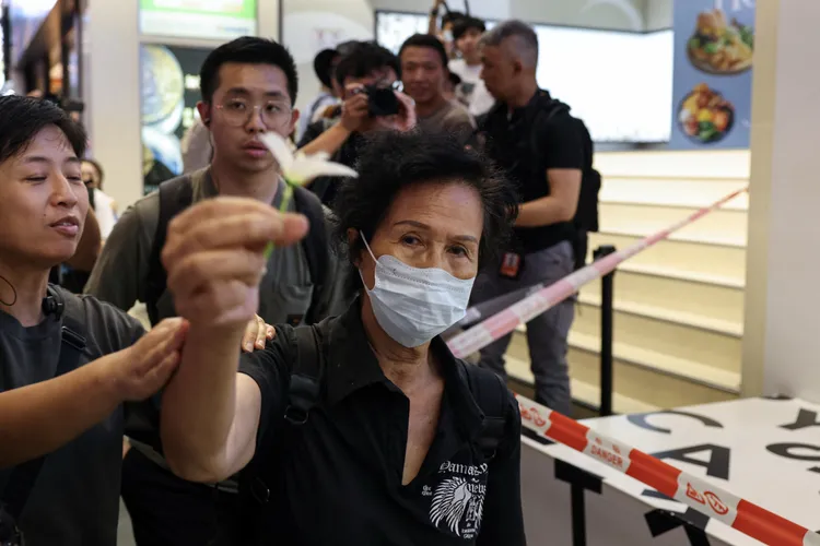 女子手持一朵白花也遭警察關心「護送」。路透社