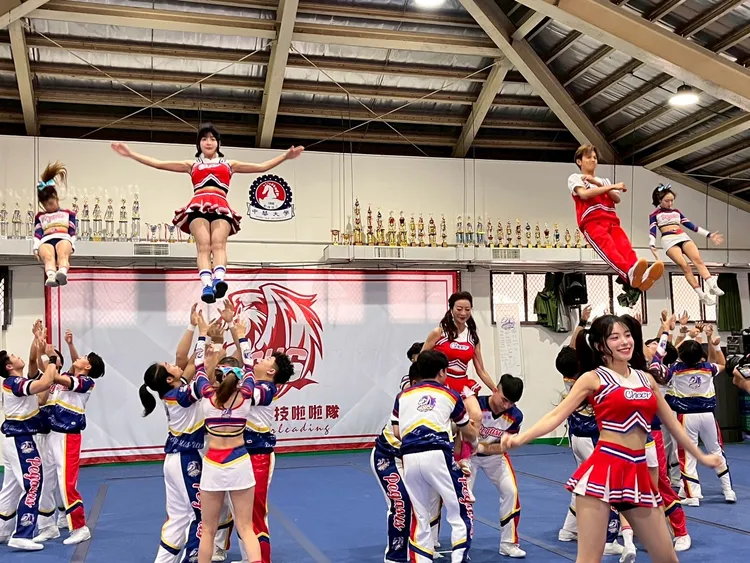 籃籃（左二上）、正在被抬起來的楊繡惠以及阿翔（右二）等一同體驗競技啦啦隊。民視提供