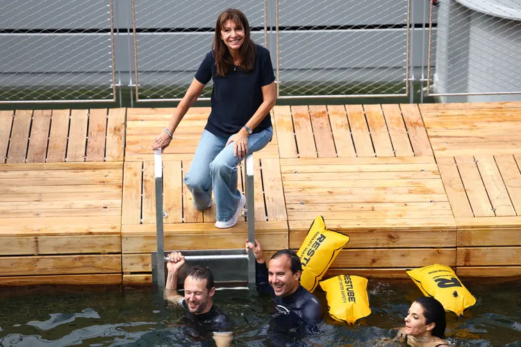 市長伊達戈爾坐在河畔看著民眾戲水。路透