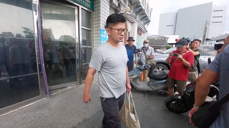 彭振聲兒子提著母親遺物包包，步出市立殯儀館離開。凃建豐攝