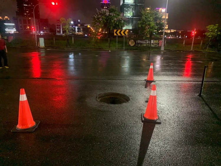 人孔蓋被水沖走，警方以交通錐示警。民眾提供