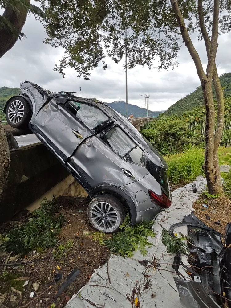 休旅車衝落邊坡後後輪著地，前輪則掛在護欄上。民眾提供