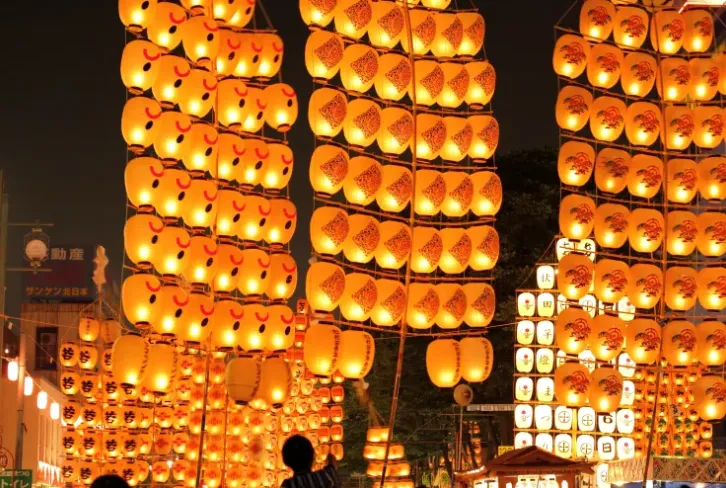 秋田竿灯祭由表演者以肩、额、腰平衡高举上千根灯笼竹竿祈福。乐天旅游提供