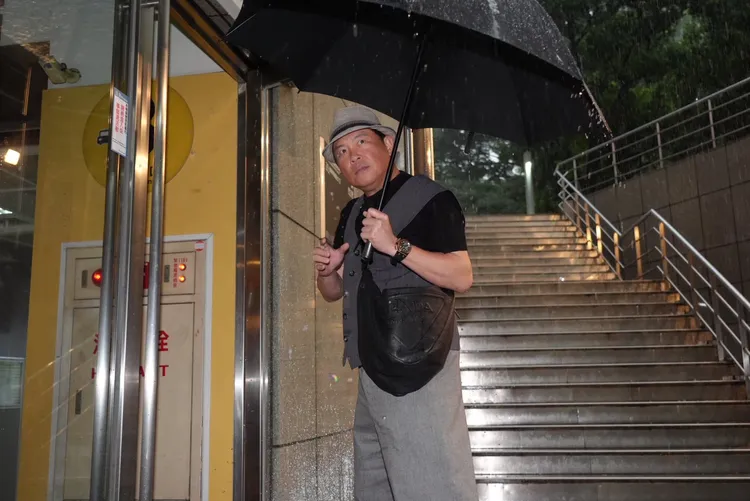 曾國城撐傘到場。彭欣偉攝