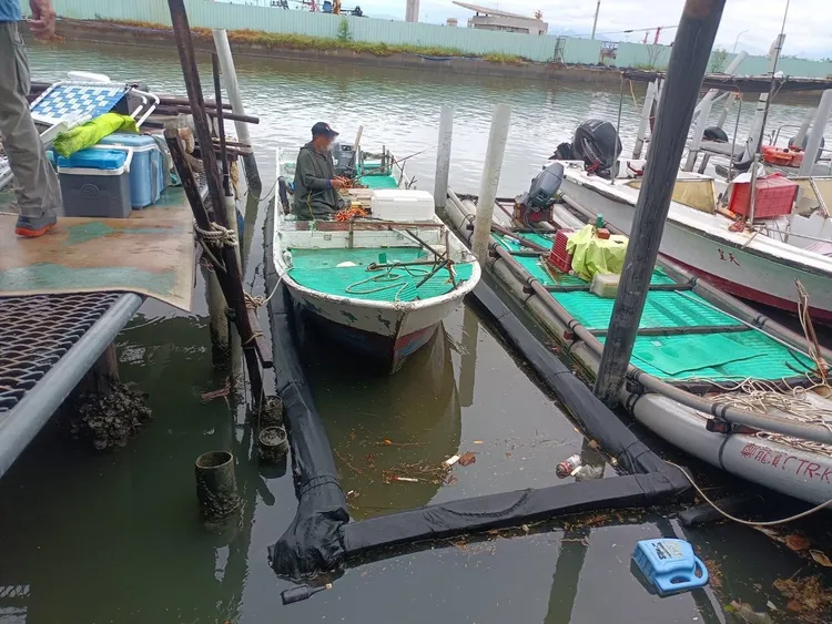 海巡發現2名民眾竟在颱風天，搭乘船型浮具在港區疑似從事垂釣，立即戒護上岸。海巡提供