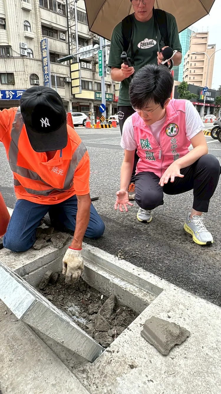 陳俞融與包商打開水溝蓋，發現工人在人行道完工後未移除塑膠板，導致「有蓋無溝」造成淹水。陳俞融提供