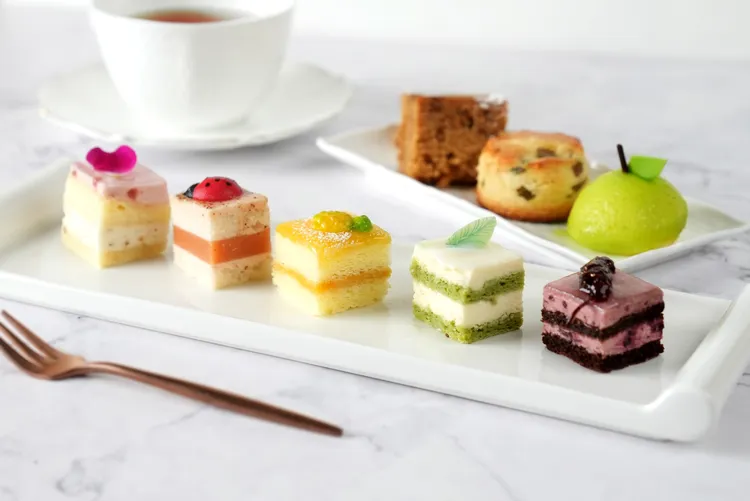 松鶴餐廳下午茶券每本親民價7萬2000元，享7.3折優惠。上排左起為無花果蛋糕、芒果青司康、青蘋果慕斯，下排左起荔枝玫瑰慕斯、紅心芭樂蛋糕、樂帶水果蛋糕、椰子慕斯、桑椹乳酪慕斯。圓山大飯店提供