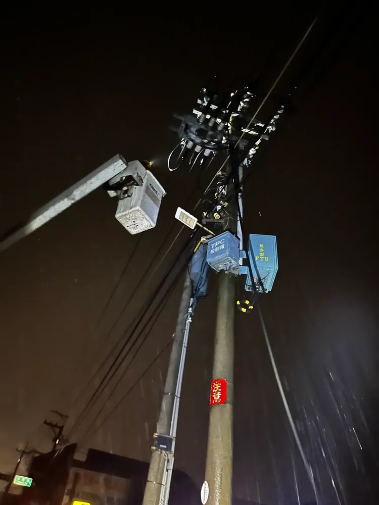台電人員冒雨搶救雷擊損壞的電力設備。台電提供