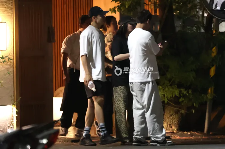 李進良（右）和田欣並肩看手機，準備和友人上車。特勤中心攝