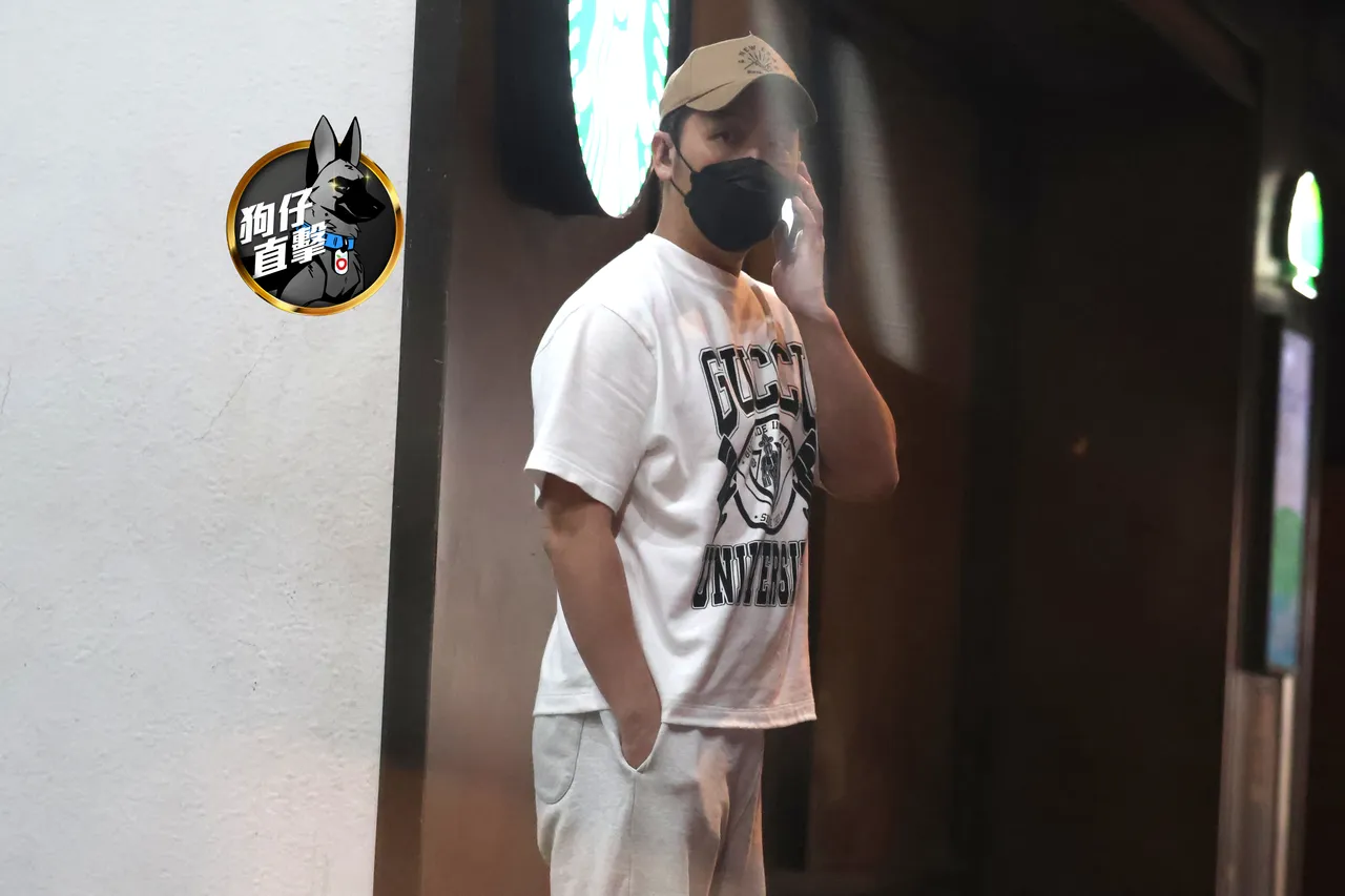 日前李進良戴名牌棒球帽和口罩,獨自走出診所講電話。特勤中心攝
