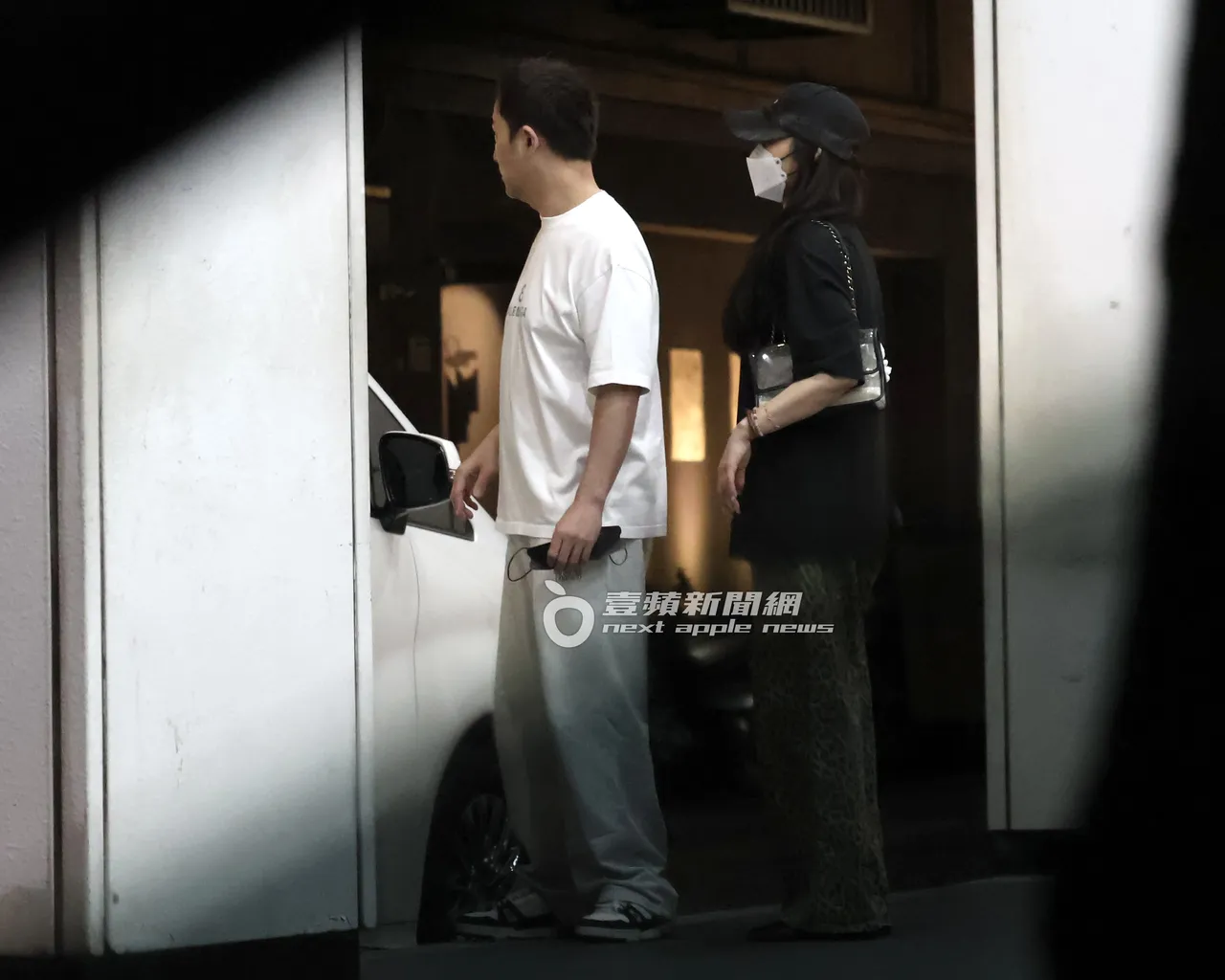 李進良(左)與田欣一同步出嘉仕美診所,在門口確認車輛。特勤中心攝