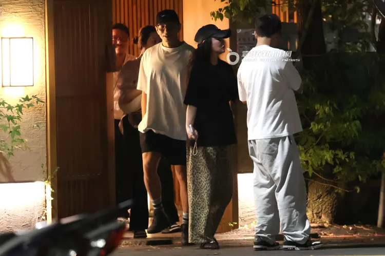 吃飽喝足，李進良（右）在餐廳門口跟田欣分享手機畫面。特勤中心攝