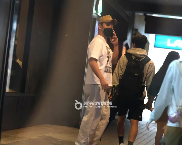 李進良步出診所，邊講電話邊回頭查看有無異狀。特勤中心攝