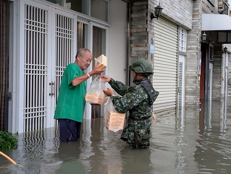 國軍官兵挨家挨戶在淹水災區送便當。第五作戰區提供