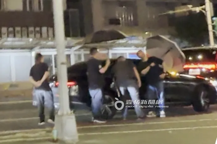 台、韓保鑣幫忙撐傘，GD降車窗和龍亨酒店幹部溝通需求。特勤中心攝