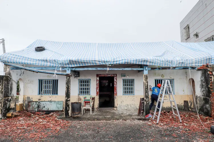 布袋186戶急需屋頂修繕，義消與民間團體協助加蓋帆布。翻攝畫面