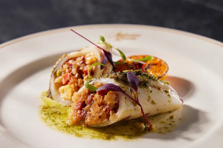 開胃菜「鑲餡透抽佐西班牙臘腸」以野生透抽包覆辣味臘腸、豆仁與香料餡料，搭配奶油青醬醬汁，香氣馥郁、口感飽滿。業者提供