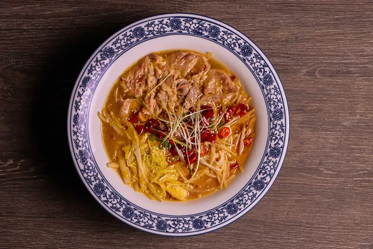 長安麵點節「秦椒酸湯肥牛」，以陝西秦椒與十餘種辛香料熬製酸香湯底，搭配滑嫩肥牛與時蔬，湯色紅亮、酸辣開胃。板橋凱撒大飯店提供