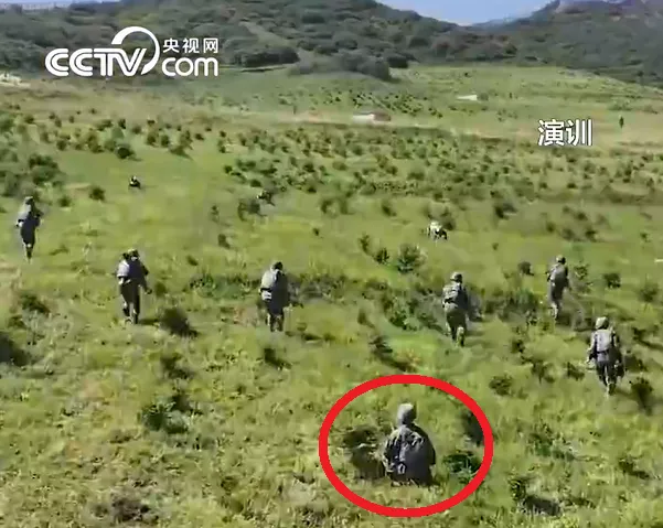 機器狼協同解放軍躍進衝鋒，實則後方有人（紅圈）在遙控。翻攝解放軍網