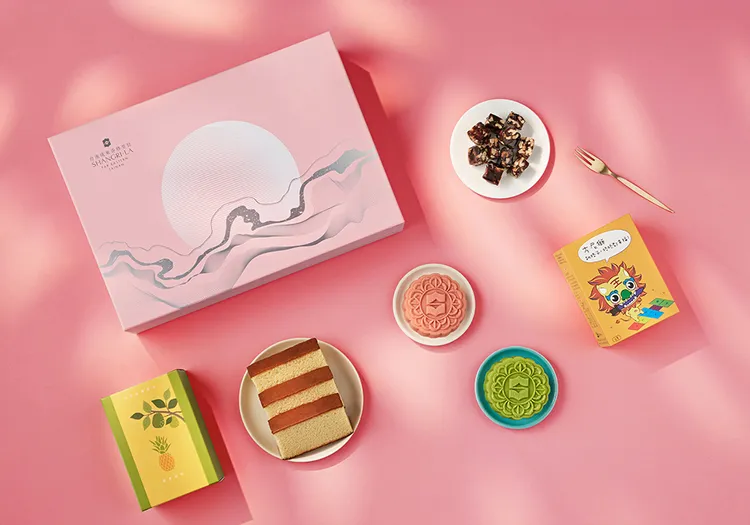 台南遠東香格里拉飯店「善月」中秋禮盒採溫潤粉色設計，內容包括兩款桃山皮月餅、金鑽鳳梨蜂蜜蛋糕與由瑞複益智中心學員手作的南棗核桃糕，傳遞節慶祝福同時實踐公益行動。業者提供