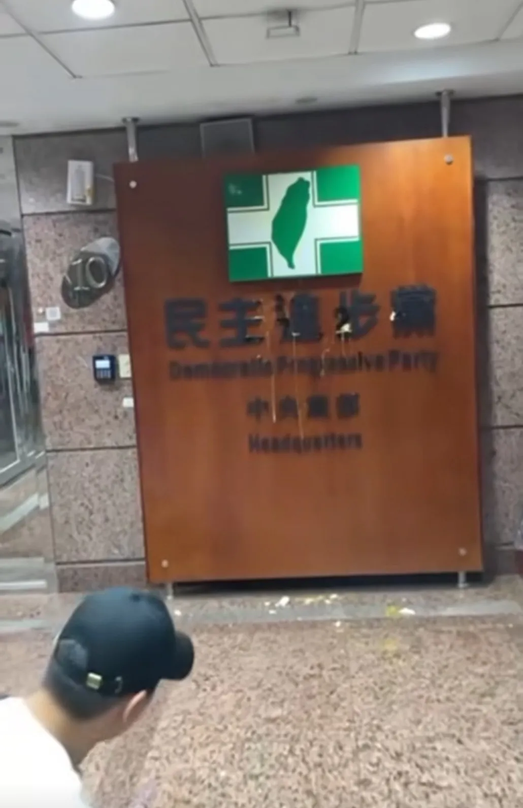 40岁李男以棒球投手姿势丢鸡蛋砸民进党中央党部招牌。翻摄自Threads