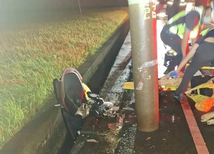 機車自撞電桿後噴飛，卡在路旁圳溝，幾乎全毀。翻攝照片