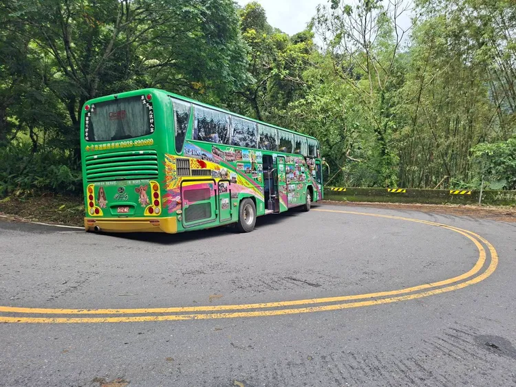 遊覽車卡彎道路面，花2小時才脫困。翻攝畫面