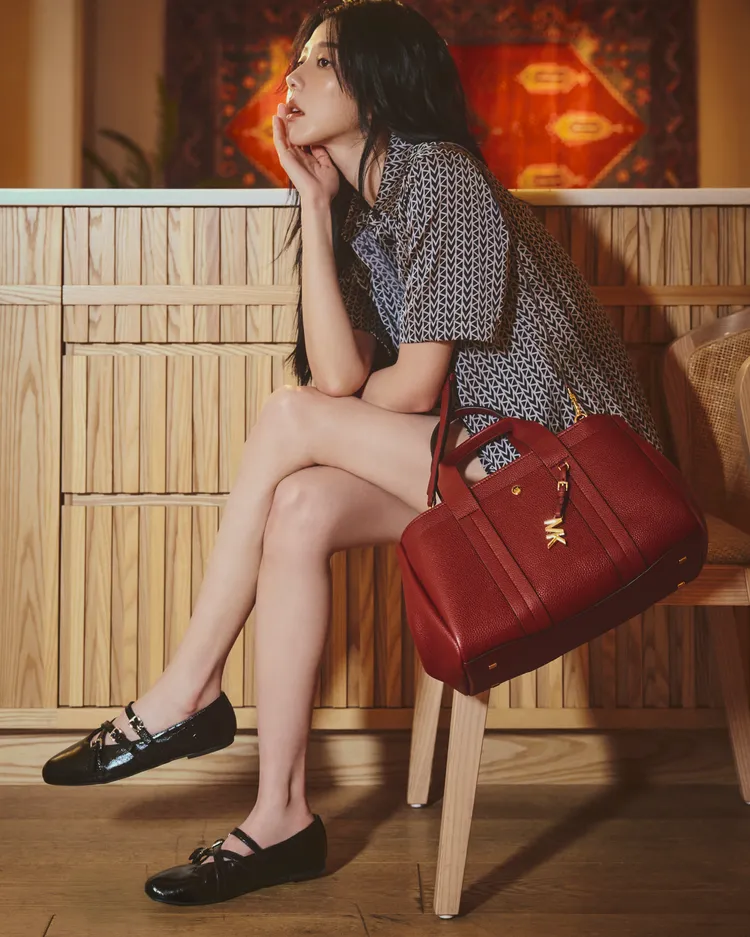 邵雨薇以MK2000標識圖案的黑白緞面套裝，搭配桑椹紅Romee Bag小型肩背提包。品牌提供