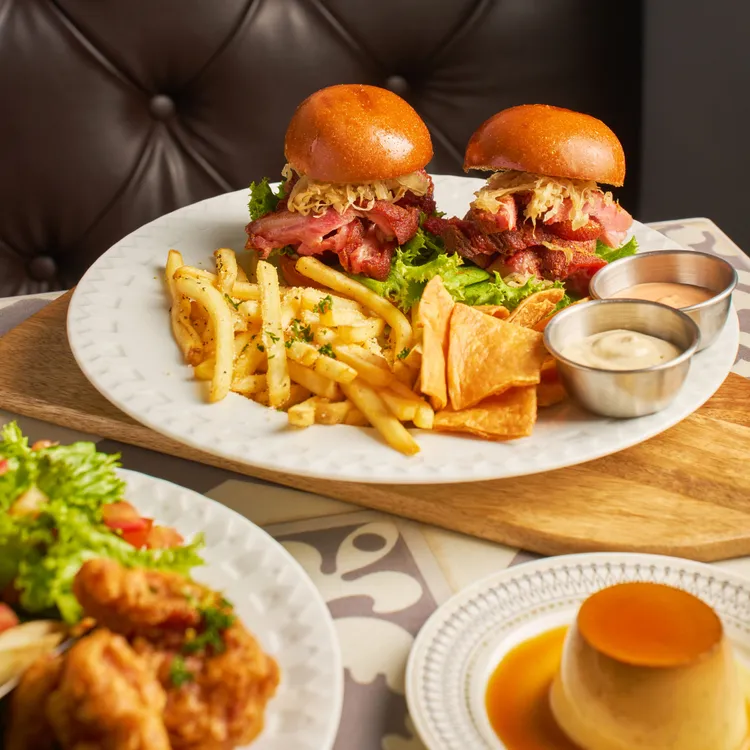 最大亮點是採用德式火烤豬腳切片及獨門酸菜的「美軍俱樂部聯名迷你豬腳漢堡」。業者提供