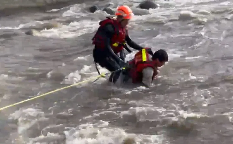 救援人員緊緊拉住受困釣客。新竹縣消防局提供