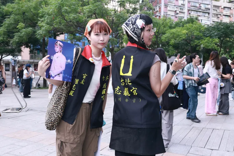 Tammy（左）、YW穿著粉絲特製的「志龍宮」宮廟背心同樂。彭欣偉攝