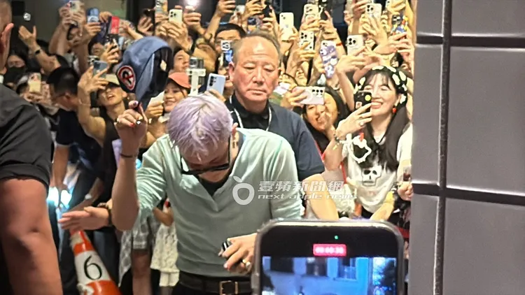 GD脫帽與現場粉絲致敬，和他身後的「手機牆」行程強烈對比。特勤中心攝