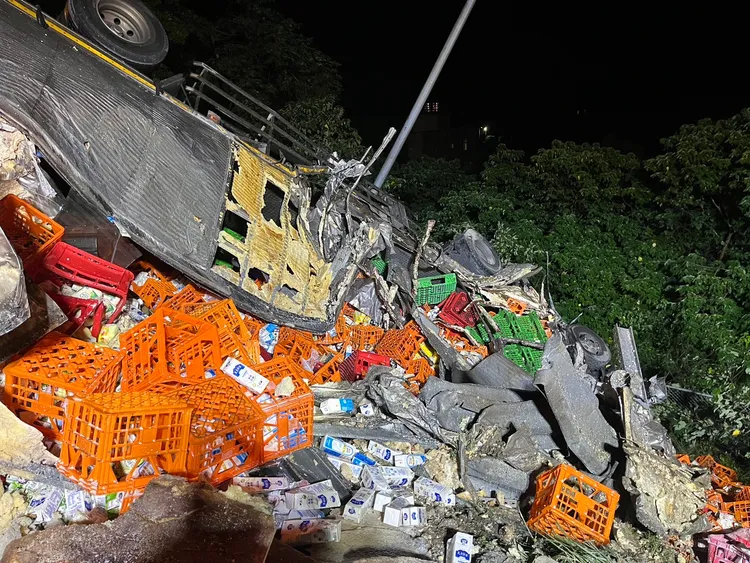 國道3號聯結車撞上外側車道的故障車後翻覆，所載運的鮮奶散落一地。民眾提供