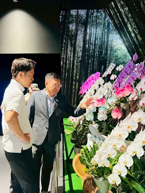 大阪府知事吉村洋文(前)26日造访大阪世博TECH WORLD馆,馆长邱挥立(后)特别介绍台湾引以为傲的兰花产业,指出全球市场约1/3的兰花来自台湾。 (TECH WORLD馆提供) 中央社