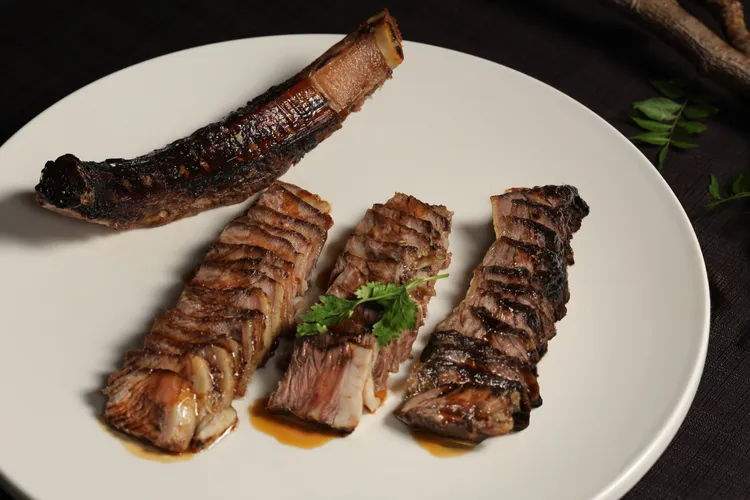 晶華軒主廚鄔海明在晶華軒推出以經典粵式燒臘技法打造的「蜜汁戰斧牛」，展現傳統烹藝與創意的結合。台北晶華提供