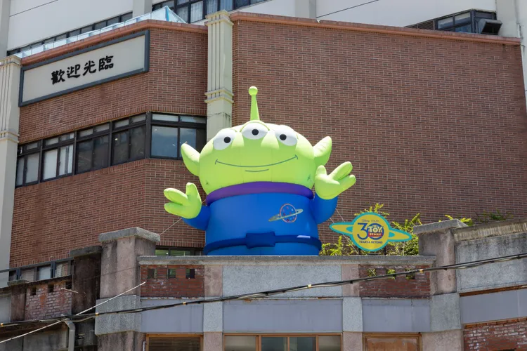 高達6公尺的三眼怪在永樂市場紅磚牆上展開雙臂。業者提供