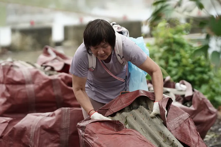 屏東家扶志工團隊協助林姓民眾整理被吹翻的屋瓦。翻攝畫面