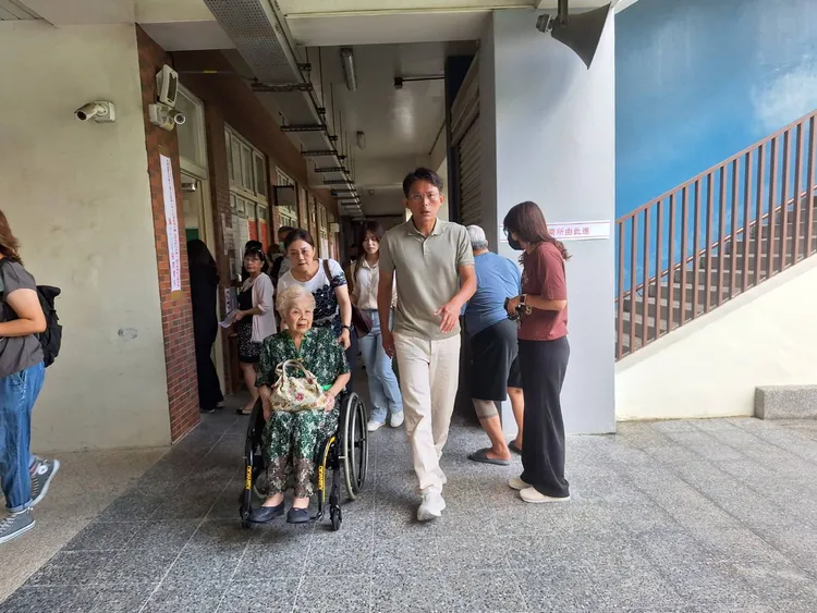 民眾黨主席黃國昌陪同柯文哲母親何瑞英至民富國小投票。民眾黨提供