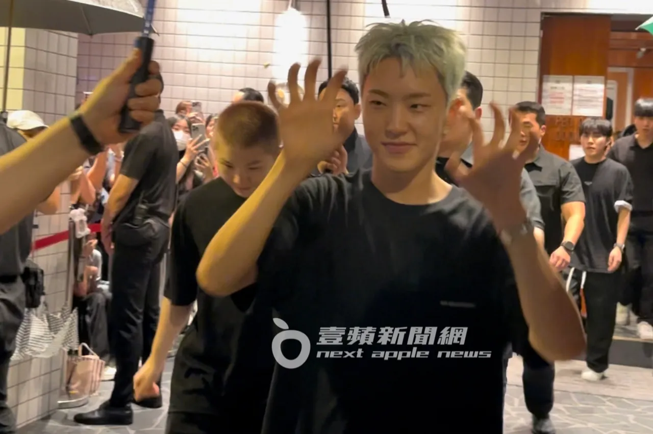 HOSHI(右)与WOOZI庆功结束,离开「金猪食堂」向粉丝们比出虎爪宠粉。特勤中心摄