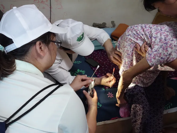 大林慈濟醫院簡瑞騰副院長關懷受災戶時，協助一位90歲阿嬤褥瘡清創。大林慈濟醫院提供